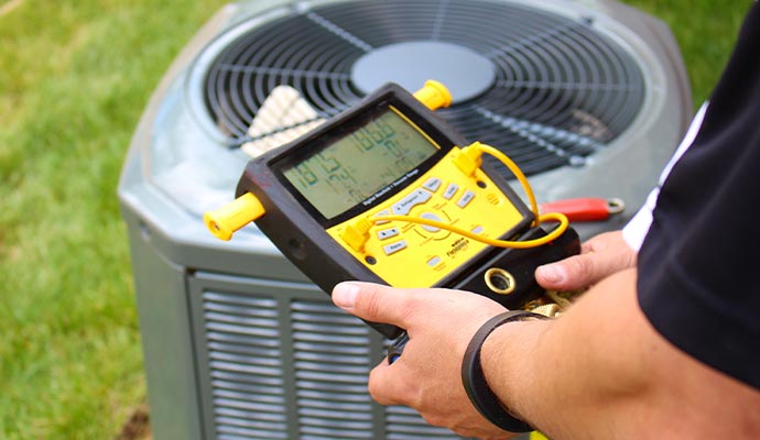 Technician using a digital device to inspect a heating system
