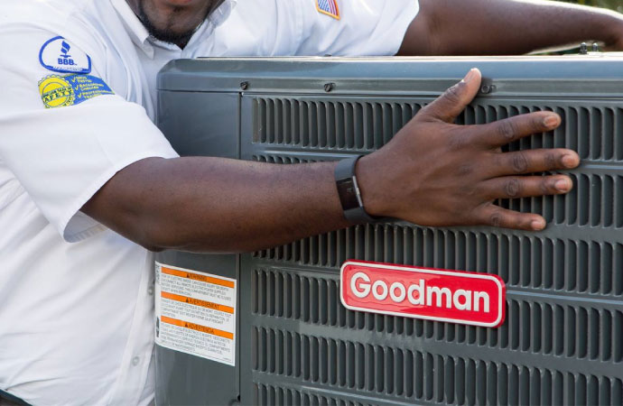 An expert holding a Goodman HVAC product